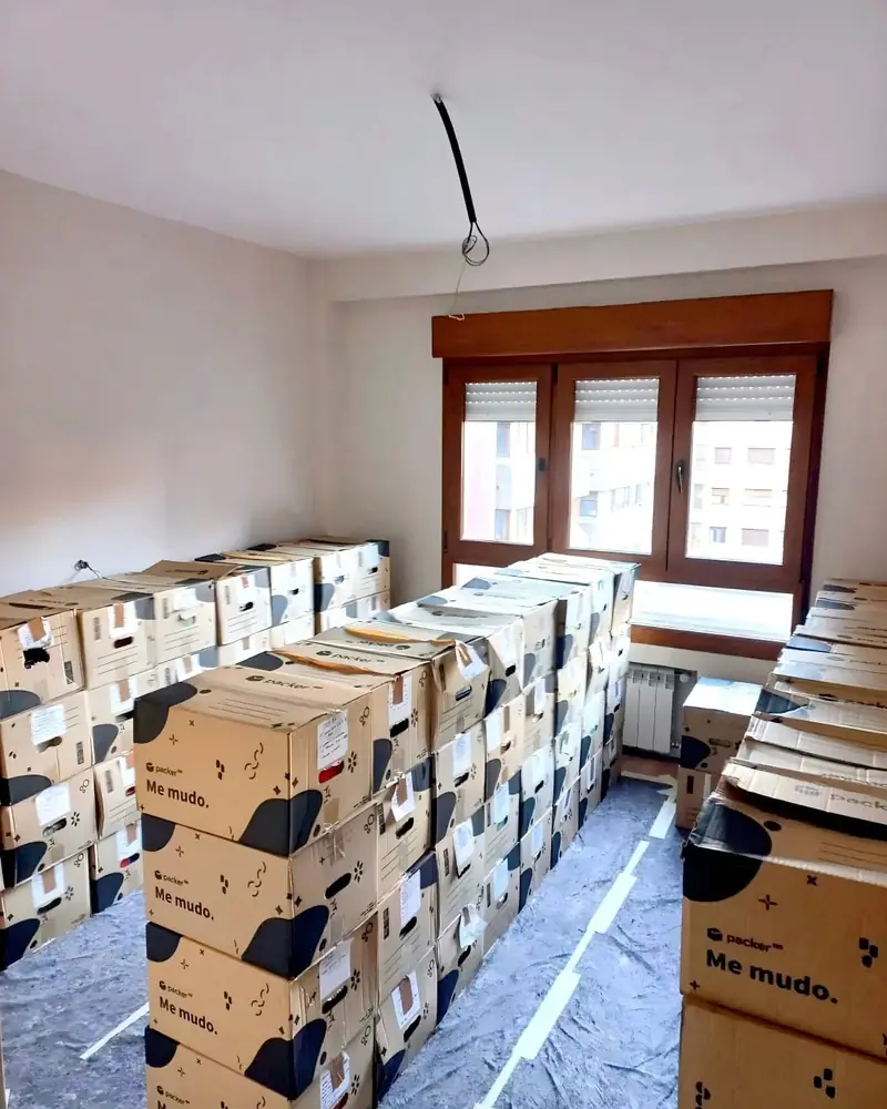 Habitación con cajas de mudanza preparadas y el suelo protegido